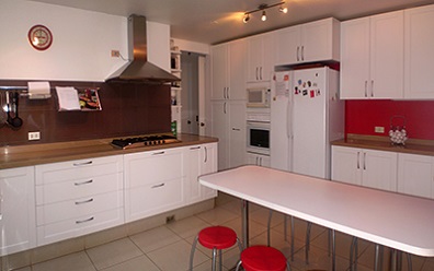 Muebles de cocina86 a medida con puertas termolaminadas en pvc blancas y cubierta de Silestone crema minerva en Lo Barnechea, Santiago de Chile